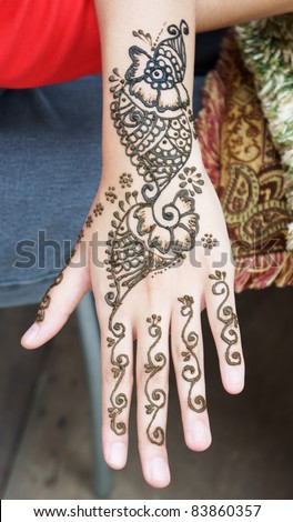 Muslim Lady hand being decorated with henna tattoo
