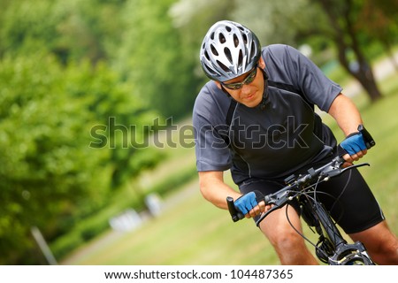 Man on bike riding fast, natural background