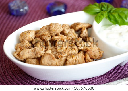 Grilled pieces of turkey with spices and yoghurt herbs and basil sauce. Light meal for people on diet.