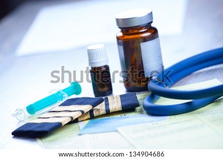 Close up of an airplane pilot\'s papers medical and pilot certificate, forms like report of eye eveluation, stethoscope and medicines. Conceptual image of medical exam.  All personal data are false.