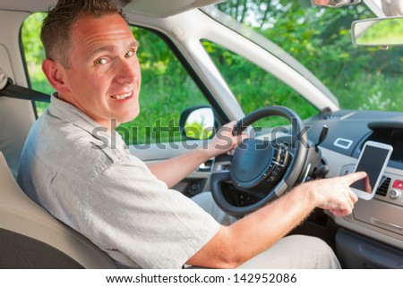 Happy man in the car using his mobile as a navigation GPS or receiving call