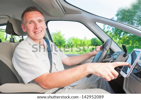 Happy man in the car using his mobile as a navigation GPS or receiving call