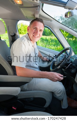 Man getting in or out the car with keys in hand