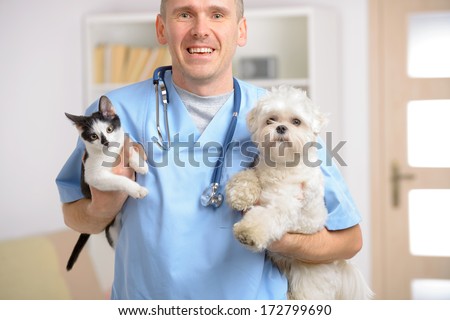 Happy Vet With Dog And Cat, Focus Intentionally Left On Smile Of Veterinary.