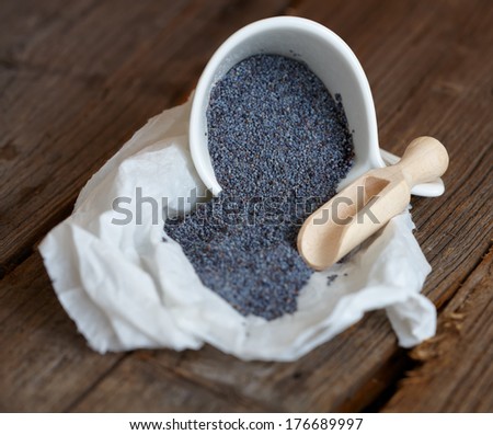 Dried organic poppy seed on wooden table