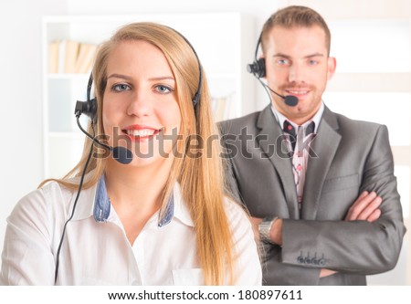 Two young Happy Telephone Operators with a headset in call center