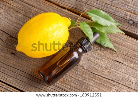 Bottle of essensial lemon oil with fresh organic fruit
