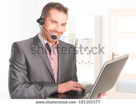 young Telephone Operator with a headset and laptop in call center
