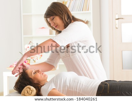 Professional Reiki healer doing reiki treatment to young woman Professional Reiki healer doing reiki treatment to young woman