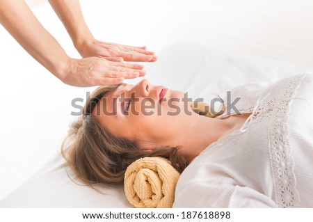 Professional Reiki healer doing reiki treatment to young woman Professional Reiki healer doing reiki treatment to young woman