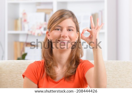 Beautiful smiling deaf woman using sign language or showing OK sign