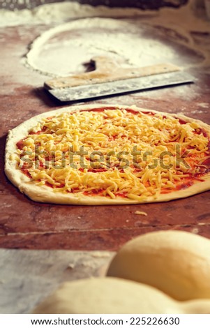 Fresh original Italian raw pizza, preparation in traditional style.