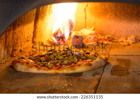 Fresh original Italian pizza in a traditional wood-fired stone oven.