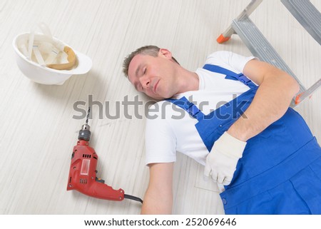 Man worker laying on a floor, concept of accident at work