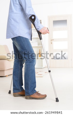 Man walking with crutches, rehabilitation after injury