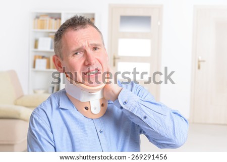 Man with a surgical cervical collar suffering from neck pain