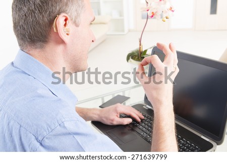 Smiling Deaf man talking using sign language on the laptop\'s cam