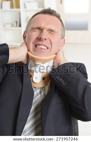 Businessman at work wearing neck brace