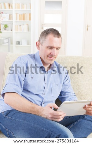 Smiling Deaf man talking using tablet at home