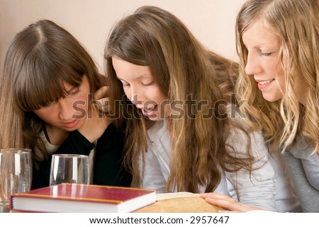 Three girls reading together at the meeting.