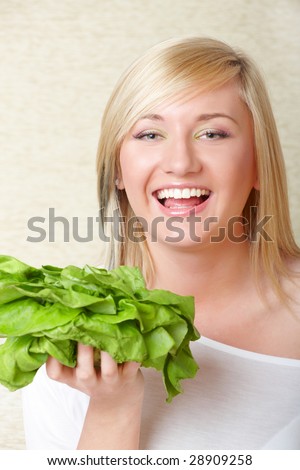 Beautiful woman laughing with head of lettuce, healthy food concept