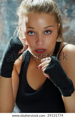 Caucasian young woman fighting wearing wearing black hand wraps