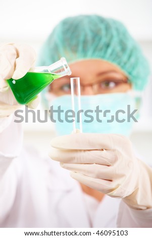 Closeup of a female researcher holding up a test tube and a retort in the laboratory
