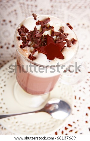 Two cups of hot chocolate with whipped cream. Delicious drink with nice decoration, standing on elegant plates.