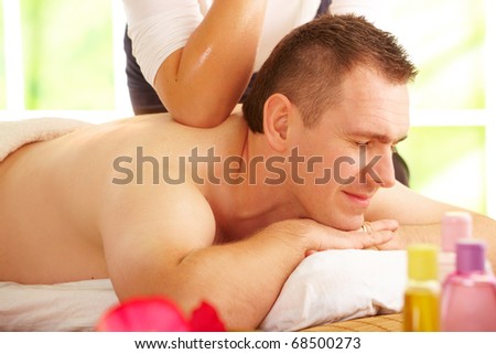 Male enjoying kind of Thai massage treatment with female hand back