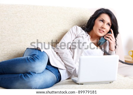 Portrait of beautiful woman laying on sofa with netbook and phone