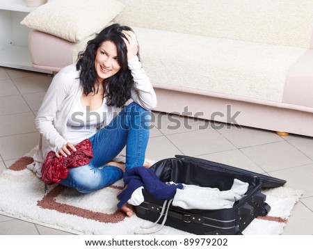 Young girl preparing her luggage before travel. She is in doubt of what to pack