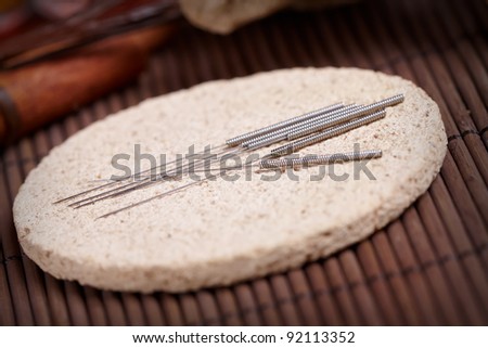 Acupuncture needles laying on the stone mat, TCM Traditional Chinese Medicine concept photo