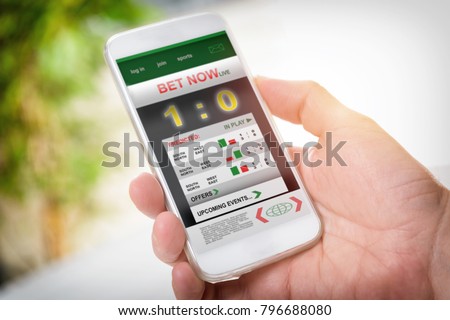 Man betting on sports, holding smart phone with working online betting mobile application