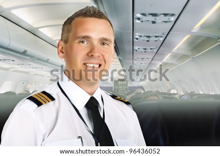 Airline pilot wearing uniform with epaulettes on board of passenger aircraft.
