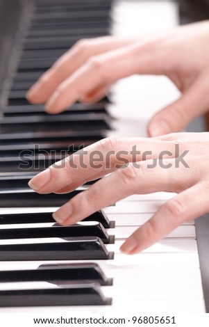 Woman's hands playing music on the piano