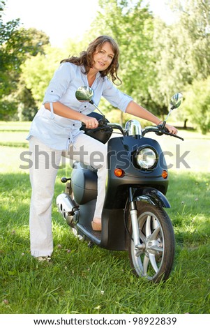 Woman with retro motorbike scooter