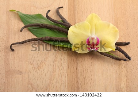 Vanilla pods and flower on a wooden background