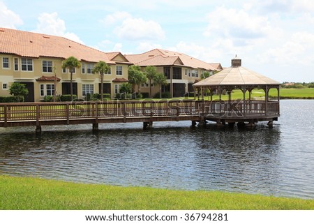 Tropical gazebo and walkway on a small lake in a Florida community