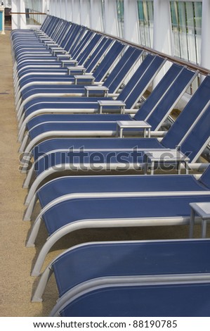 Royal blue lounge chairs for lying in the sun on a cruise ship deck