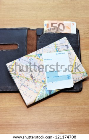 Traveling concept composition with wallet, money, map and an airplane boarding pass