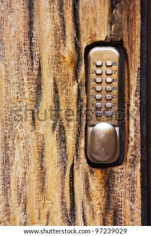 PIN keypad with numbers and letters carved in the wooden door
