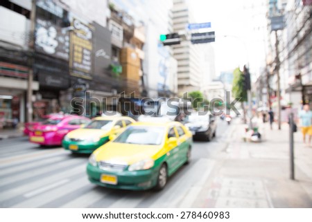 Blurred unfocused city view at day time. Unfocused cars in the way.