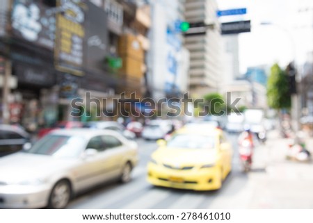 Blurred unfocused city view at day time. Unfocused cars in the way.