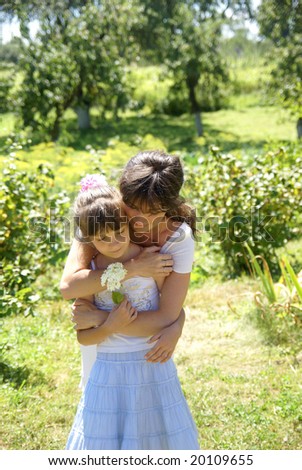 Mother and the daughter admire a flower