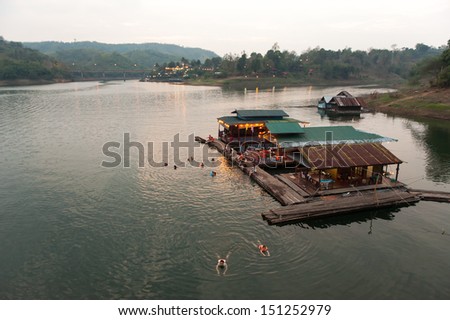 SANGKHABURI,THAILAND-FEBRUARY 24 people swim in the lake with floating house at Sangkhaburi lake on February 24,2013 in Sangkhaburi,thailand.