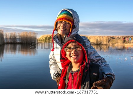 Portrait of mother and son with sunrise at the lake,family photo
