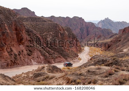 ZHANGYE, CHINA -OCTOBER 19:The tourist car visiting Danxia landform on October 19, 2013 in Zhangye, China. Danxia landform is formed from red sand stones and conglomerates of largely Cretaceous age.