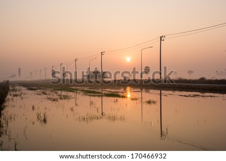 Country road on sunrise and the electric pillar , silhouette of view