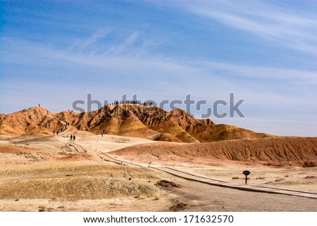 ZHANGYE, CHINA -OCTOBER 19:The tourist visiting Danxia landform on October 19, 2013 in Zhangye, China. Danxia landform is formed from red sand stones and conglomerates of largely Cretaceous age.