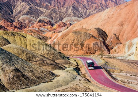 ZHANGYE, CHINA -OCTOBER 19:The tourist bus visiting Danxia landform on October 19, 2013 in Zhangye, China. Danxia landform is formed from red sand stones and conglomerates of largely Cretaceous age.